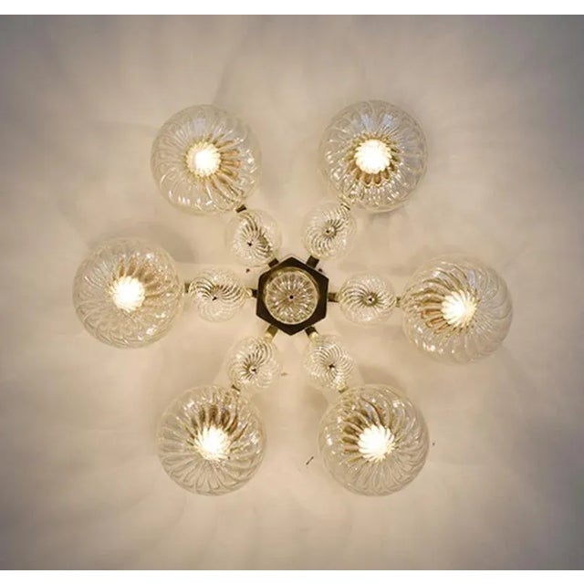 Italian modern flushmount with clear glass globes with twisted texture on solid brass frame in lacquered polished finish,...