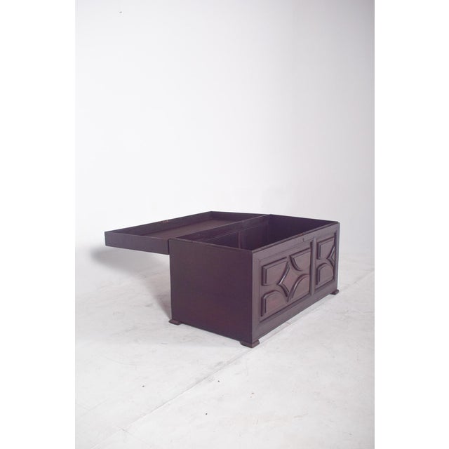 Padded wooden chest. with a hinged lid and a dark finish, it has a sturdy and sober design, highlighting the padded panels...