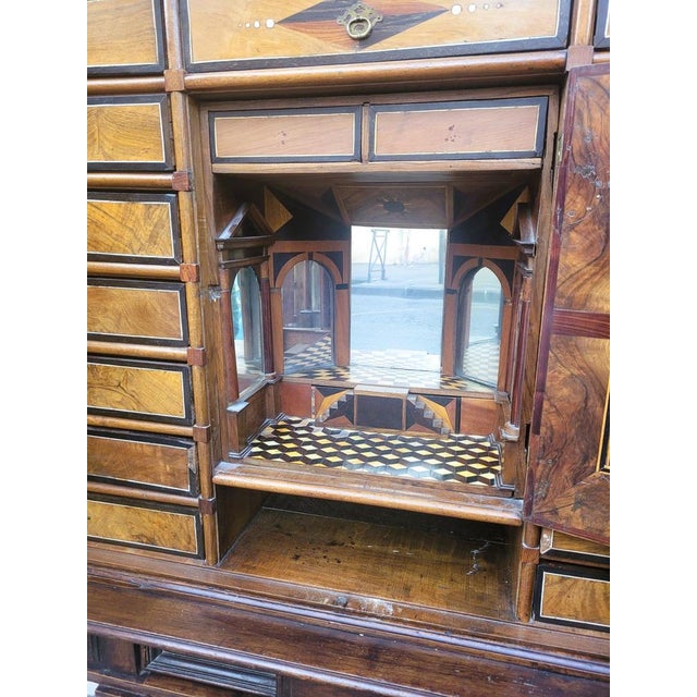 Large cabinet on its base, opening on the front with 2 large doors decorated with marble plaques, and revealing a series...