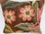An exquisite antique-style pillow upholstered in richly woven 19th-century tapestry, set against a deep warm brown ground...