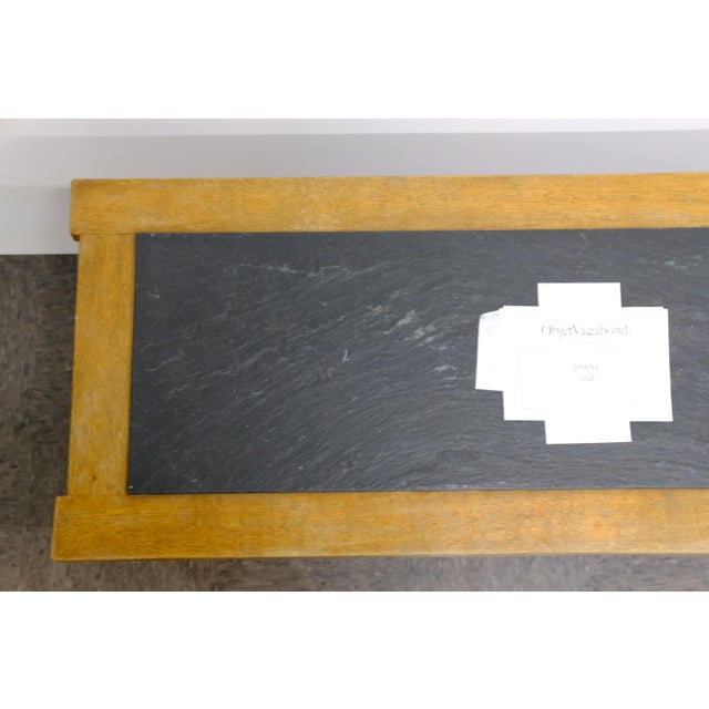 A coffee table with a rectangular black slate inset top set within a solid wood frame, raised on four straight, tapered...