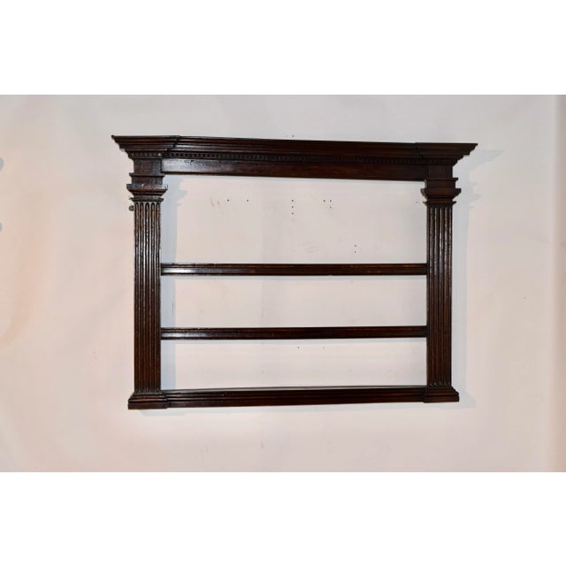 Late 18th century oak wall shelf from England. The top has an elegant crown with dentil molding, over two columned side...