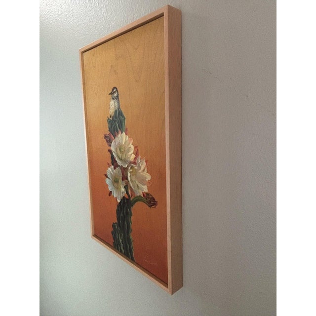 This artwork features a Cactus Wren perched atop a vibrant desert bloom, showcasing the intricate details of both the bird...