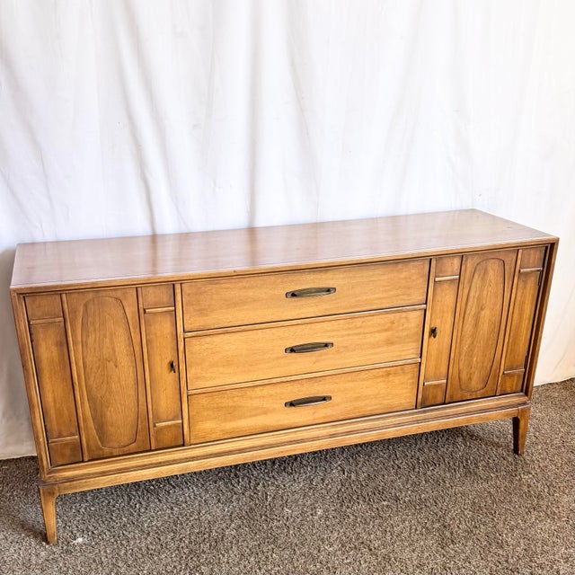 This vintage Mid Century Modern credenza showcases clean architectural lines paired with the warmth of richly grained...