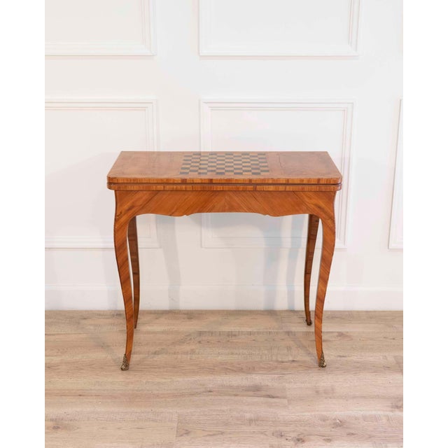 An elegant French game table reflecting the refined craftsmanship of the Louis XV period, dating to the eighteenth...