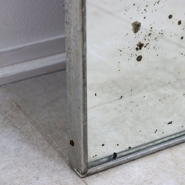 This imposing 1970s mirror is a true piece of industrial design, perfect for those seeking a raw, lived-in aesthetic...