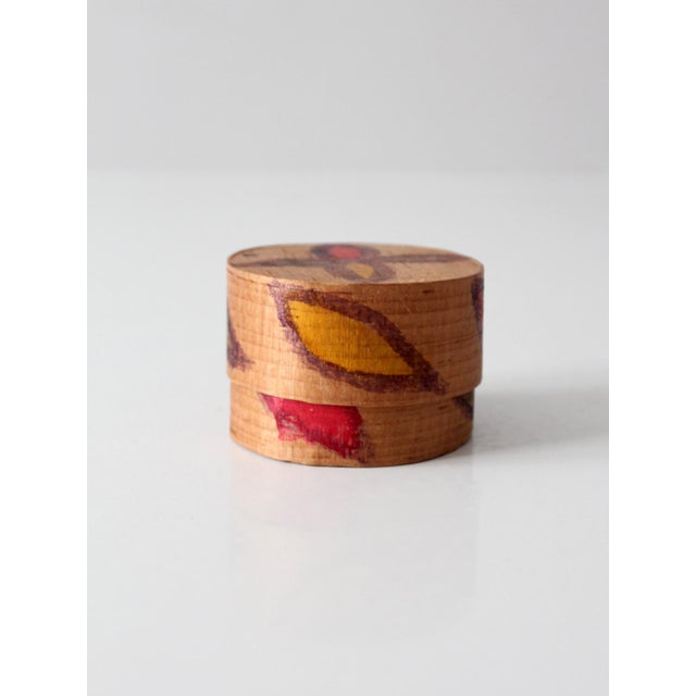 A small vintage Guatemalan folk art wooden box, hand painted with simple geometric and leaf forms in warm red, yellow, and...
