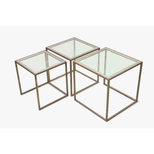 Set of Three Metal and Glass Nesting Tables Modernist / Hollywood Regency Style Europe, circa 1970s. A sleek and elegant...