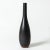 Striking stoneware vase by Carl-Harry Stålhane in a narrow, drop-shaped form. Jet black glaze with rusty color around the...