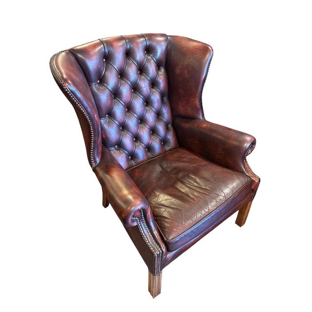 Chesterfield-style Wingback Armchair in red leather with deep-button tufting, they feature rolled arms, brass nailhead...