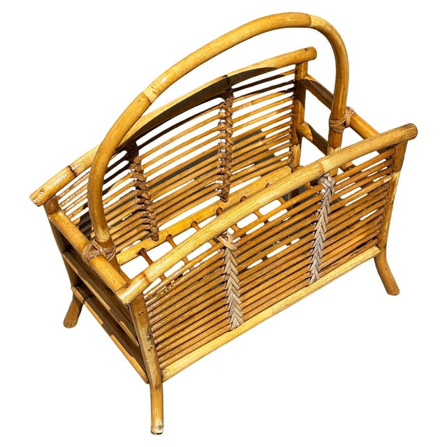 This beautifully restored 1940 rattan magazine rack featuring a carrying handle and reed rattan sides featuring a carrying...