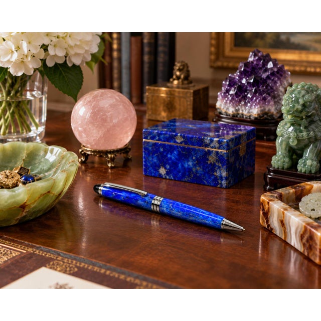 An elegant ballpoint pen crafted from genuine natural lapis lazuli, prized for its extraordinary deep blue color and...