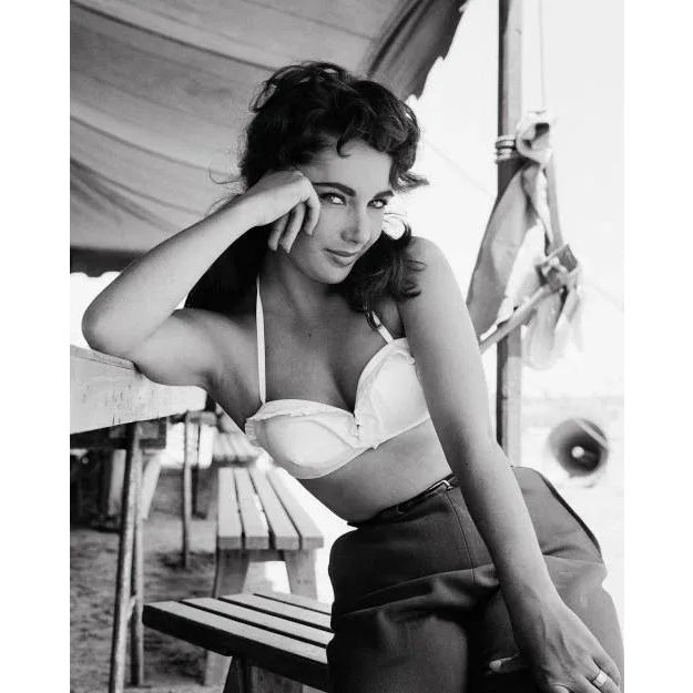 Elizabeth Taylor on the Set of "Giant" This stunning black and white image features actress Elizabeth Taylor posed...