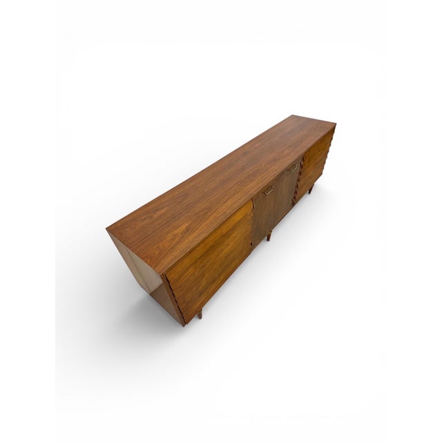 This exceptional Mid-Century Modern walnut nine-drawer dresser by American of Martinsville exemplifies timeless...