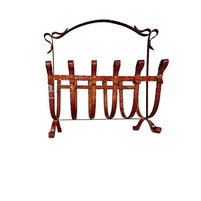 A pair of magazine racks in a style often associated with Jacques Adnet, particularly his work with leather and metal, it...