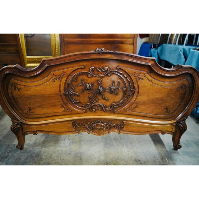 A romantic antique French bed dating to the late 19th or early 20th century. Crafted in warm walnut, the bed features a...