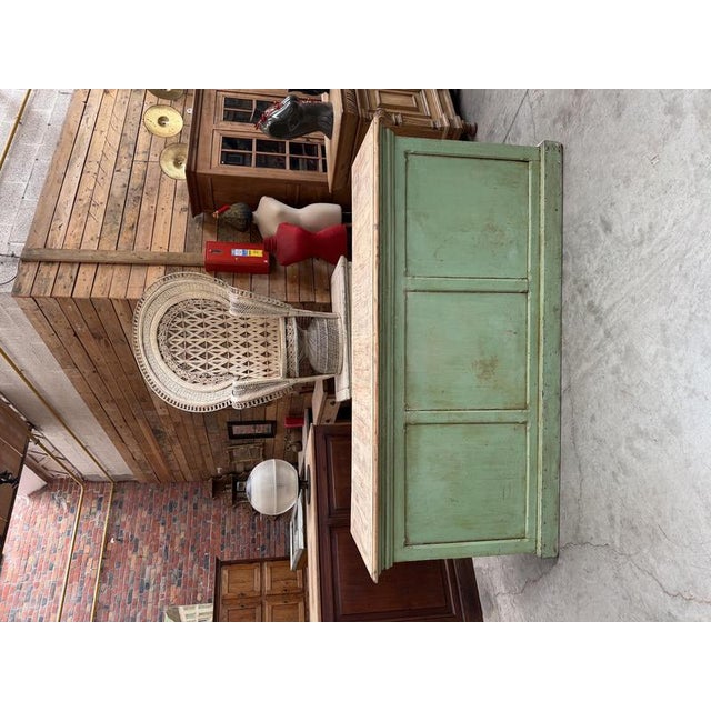 This antique florist’s counter has been fully restored. It features a green patinated base and a raw wood top. At the...