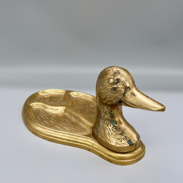 A charming and well-crafted vintage brass valet tray in the form of a resting mallard duck — the body serving as a divided...
