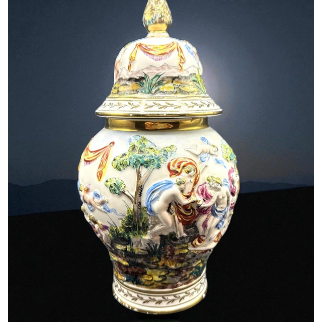 The vase depicted is a fine example of Capodimonte ceramics, renowned for its craftsmanship and decorative richness. The...