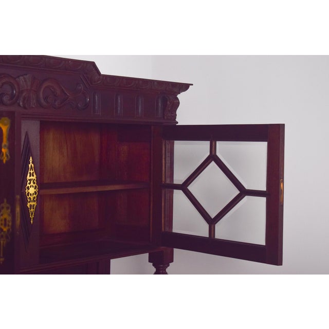 Dutch-style china cabinet with brass fittings. In dark wood with Dutch Neo-Renaissance inspiration, it stands out for its...