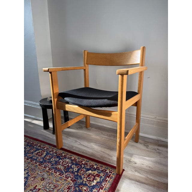 Hans J. Wegner model GE 212 armchair for GETAMA, designed in 1975. Constructed in lacquered oak with a broad curved solid-...