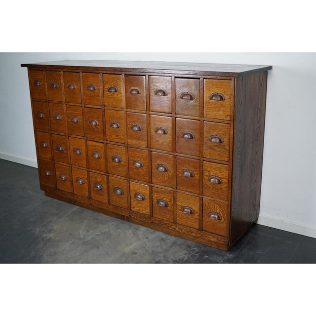 This apothecary cabinet was made circa 1940s in the Netherlands. The cabinet was used in a hardware store. It features 36...