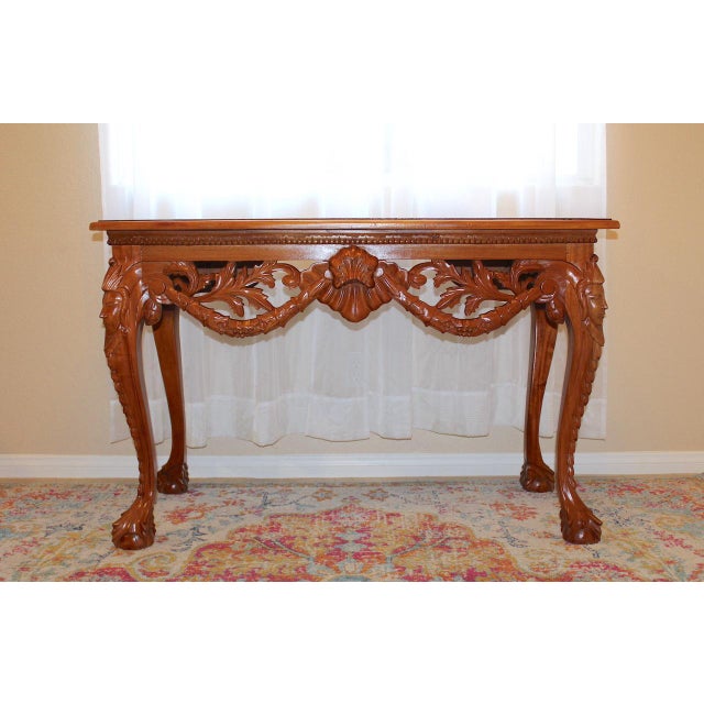 Enhance your space with this vintage mahogany console table, a stunning representation of classic Chippendale design....