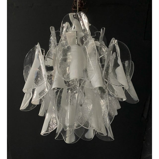 Mid century modern eight-light white and clear Murano glass petals chandelier. There are three tiers and 32 glass petals,...