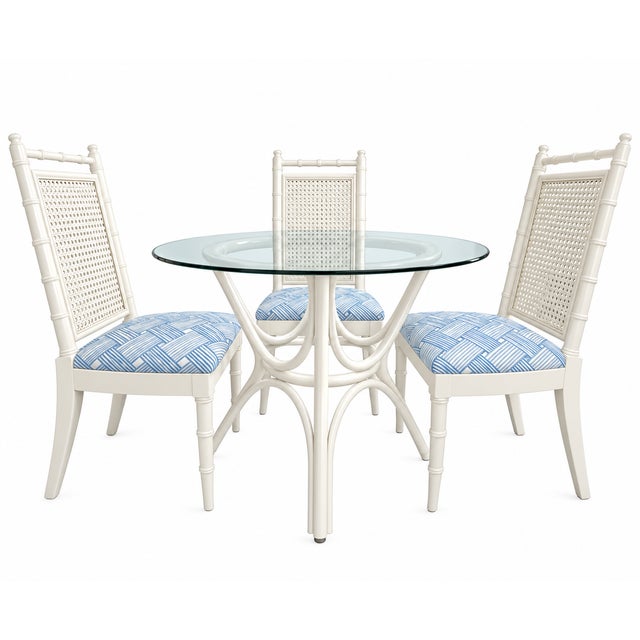 A chic vintage five-piece dining set featuring a round glass-top table and four coordinating faux-bamboo dining chairs....