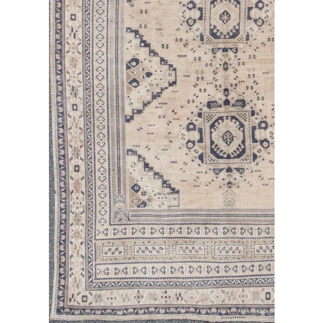 Measures: 7'1 x 11'4. Vintage Turkish Oushak Rug Featuring Soft Beige Field with Navy Tribal Design. Keivan Woven Arts /...