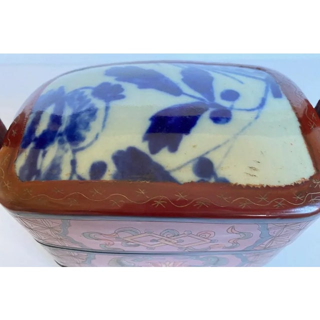 Vintage Asian tiered picnic lunch box with blue white ceramic shard top and red compartment boxes with lotus flower...