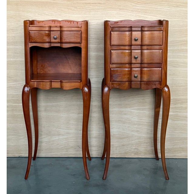 Pair of French walnut bedside tables adorned with fine Louis XV marquetry from the early 19th century. This pair of French...