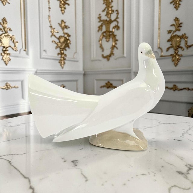 A Lladro Dove porcelain figurine, model #1015, produced in Spain and documented under piece code NB10. Introduced in 1969...
