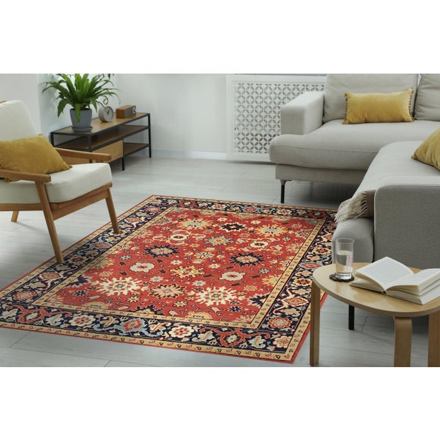 A hand-knotted wool rug, made in India and measuring 2'6"' x 12'. Floral drawing carried across the field inside a...