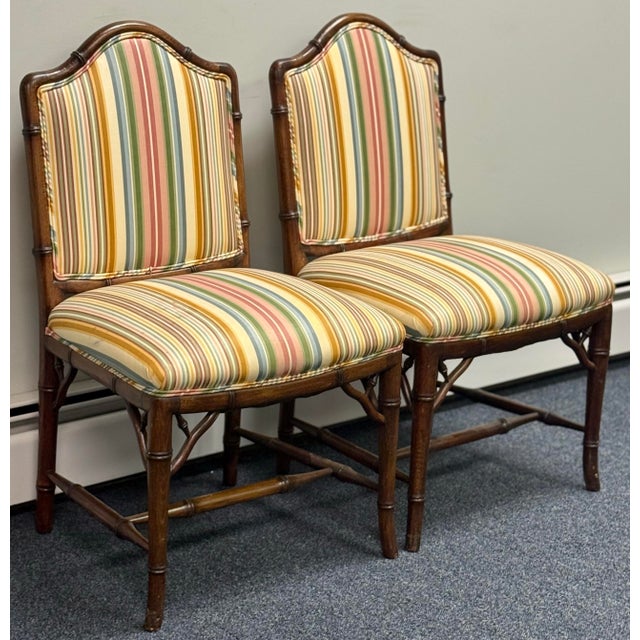 Beautiful pair of American made solid wood chairs feature meticulously carved bamboo detailing and decorative under-seat...
