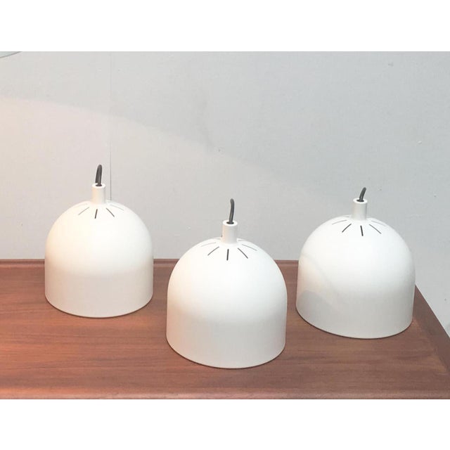 Sleek pendant lights from Staff. The shade is made of solid metal and painted white. Inside there is a reflector. This...