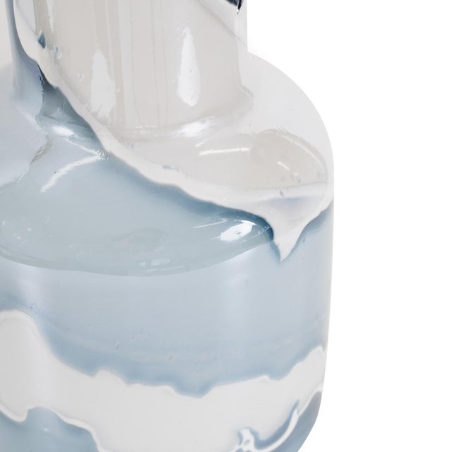 A harmonious blend of soft blue and white in a sleek, modern design. Handcrafted from glass, the flowing pattern creates a...