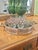 This is a vintage round gallery tray featuring a woven metal lattice surround and substantial faux-bamboo handles and...