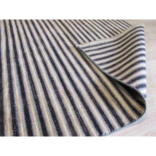 Hand-knotted in wool, this 9 x 12 Isla Striped rug carpet is a refined addition to our contemporary room-size rug...