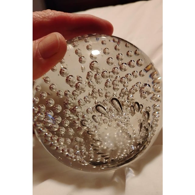A clear glass crystal ball that displays graduated controlled bubbles inside commonly known as "bullicante" art glass....