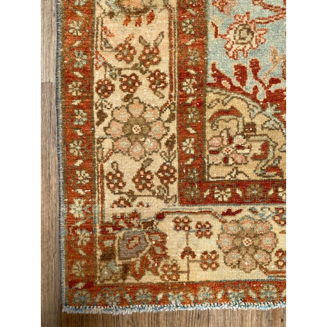 A stunning antique Persian Tafresh rug. This antique Tafresh offers a red and blue palette with blush accents.