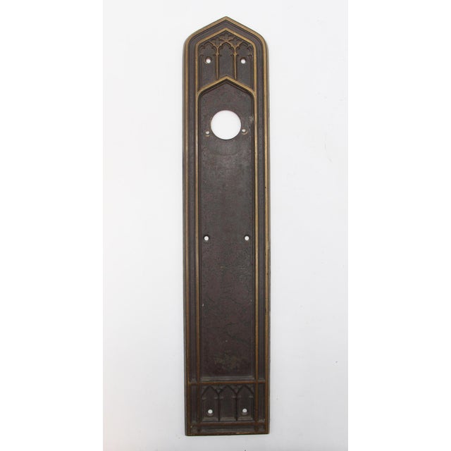 Gothic style bronze push plates with an antique patina. One plate has a cylinder lock. Made by Corbin. Priced as a pair....