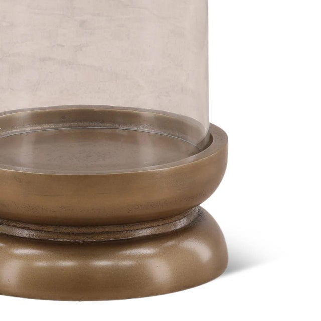 Beautiful candle holder with antiqued brass finish aluminum base and glass surround. Each may vary in patina and other...