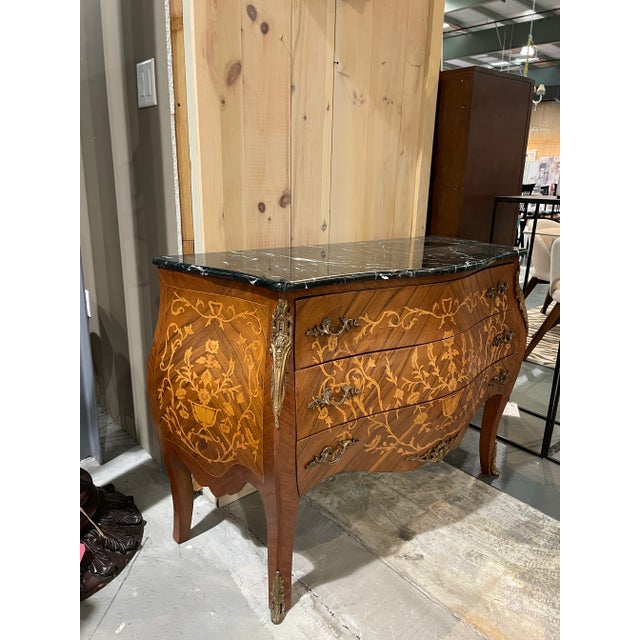 A beautifully crafted bombe chest featuring an exquisite black marble top with delicate green veining. The serpentine...