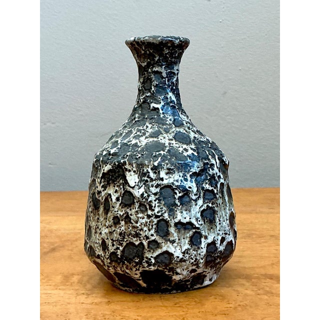 This vintage ceramic vase is a bold example of mid-century modern design, distinguished by its dramatic black and white...