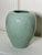 This large celadon green colored vase is gently embossed with round grapes. leaves and curled vine creating a nice tone-...