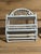 Vintage white wicker painted wall shelves units with a hanger for towels.