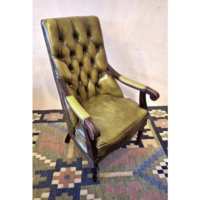 Vintage Chesterfield lounge chair in olive green tufted leather dating from about 1970. Well upholstered, very comfortable.