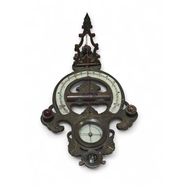 A rare 19th-century Chinese portable sundial, finely crafted in engraved and enameled bronze. This meticulously detailed...
