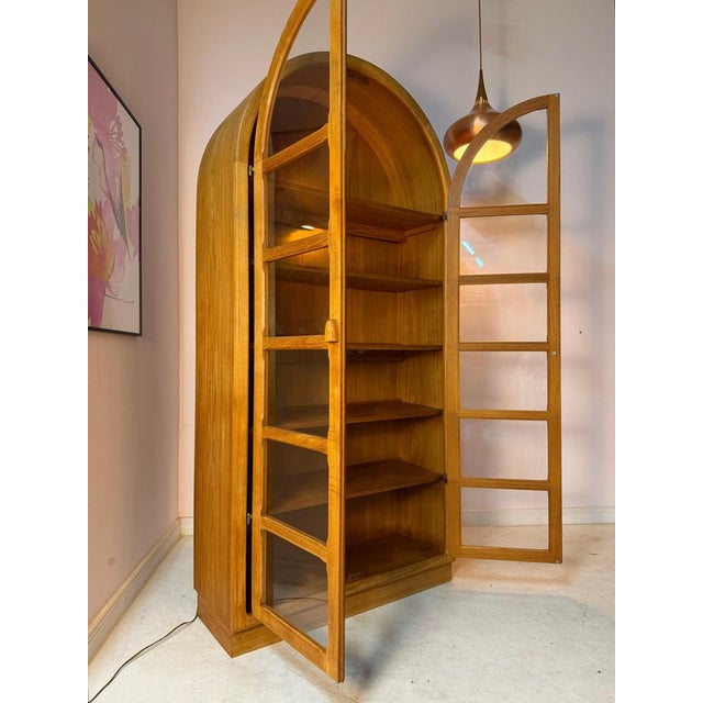 An exceptional arched display cabinet from Dyrlund, crafted from teak. The striking, architectural arched shape and two...